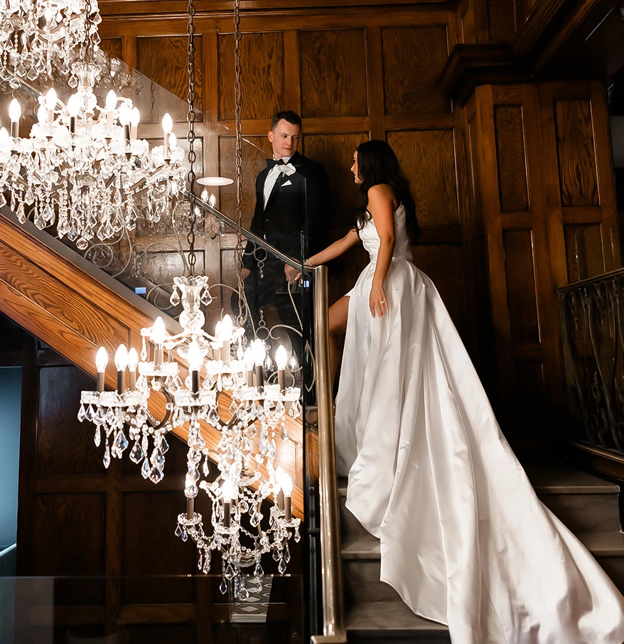 a man and woman in a wedding dress on a staircase
