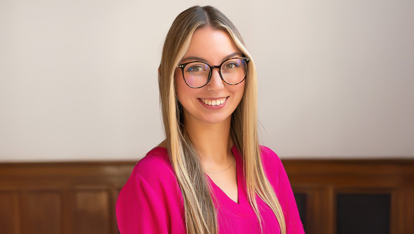 a woman wearing glasses and a pink shirt