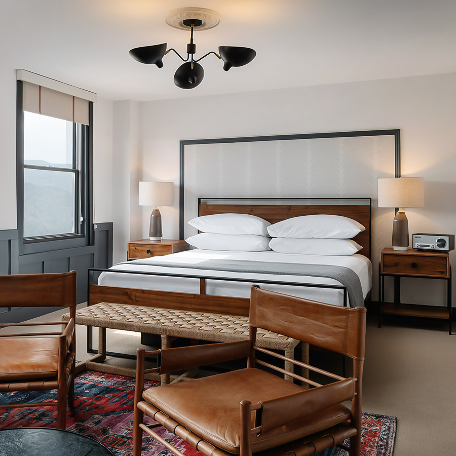a bedroom with a bed and chairs