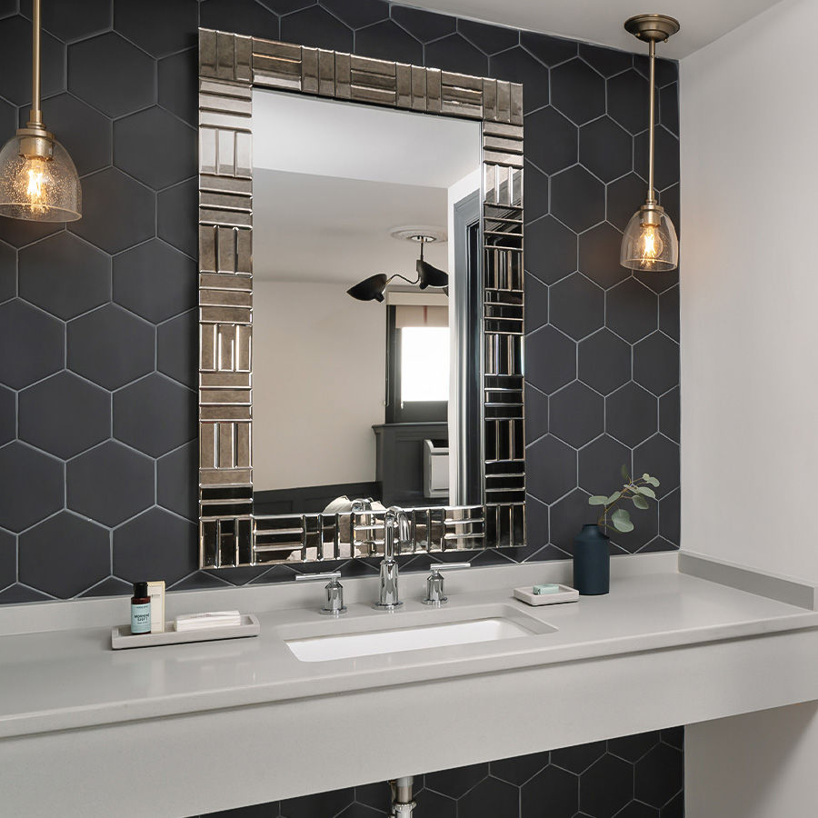 a bathroom with a mirror and a black hexagon wall