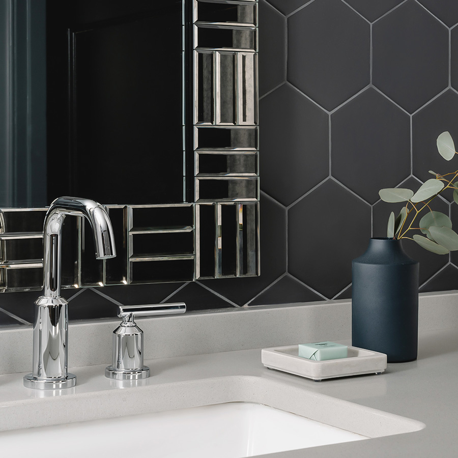 a bathroom sink with a vase of soap and a plant