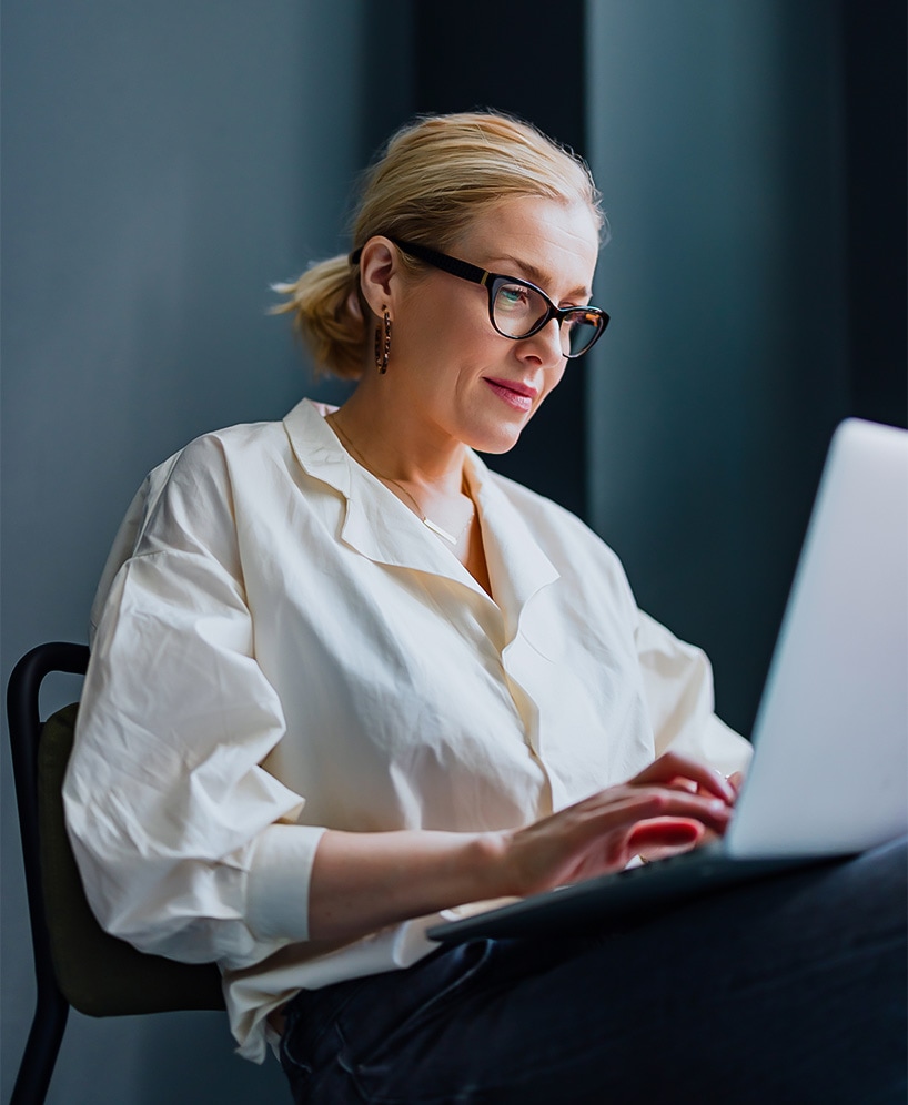a woman sitting in a chair using a laptop