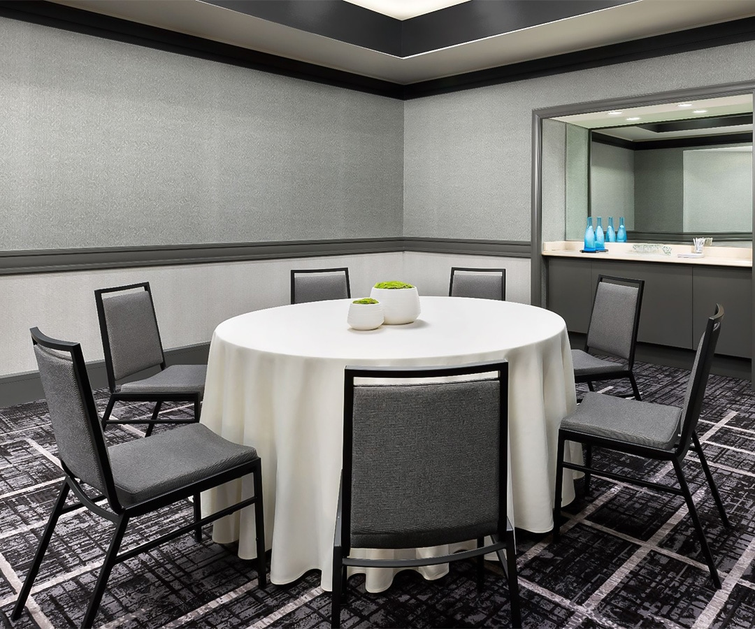a room with a round table and chairs