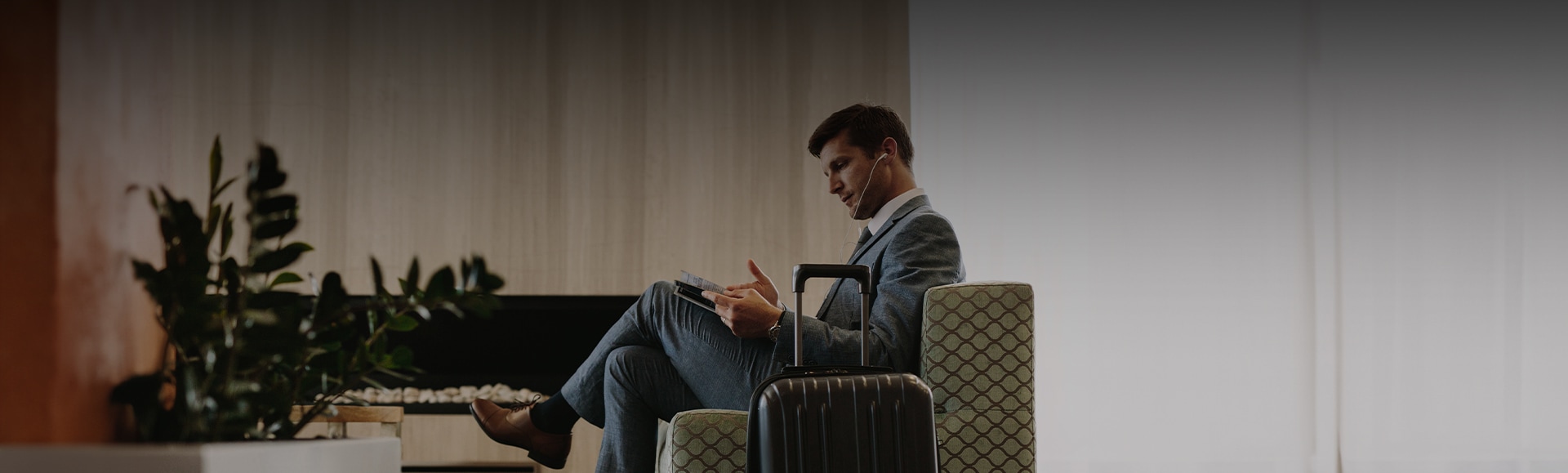 a man sitting in a chair with a suitcase and a book