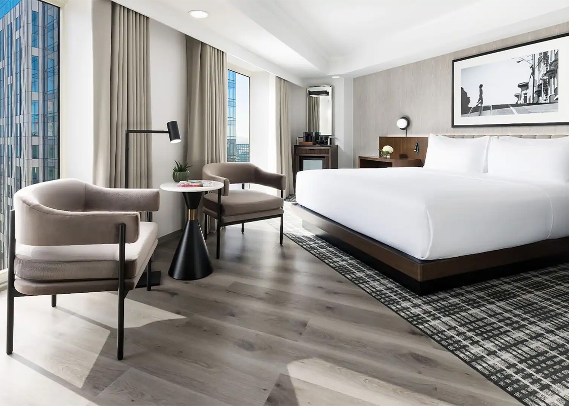 a room with a bed and chairs