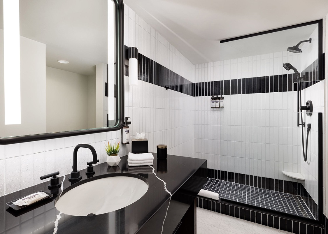 a bathroom with a black and white tiled wall