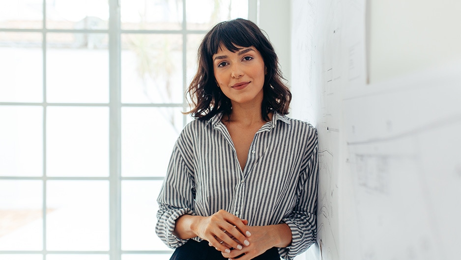 a woman leaning against a white board