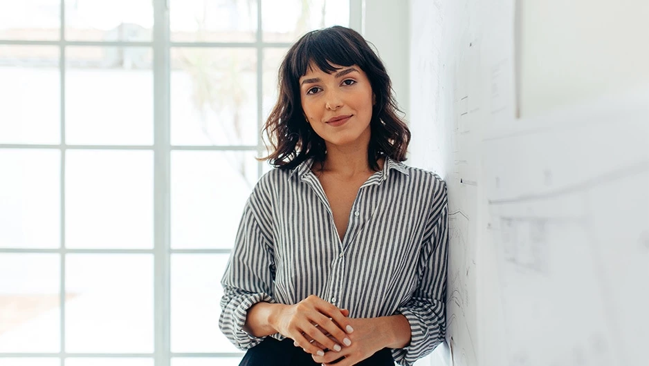 a woman leaning against a white board