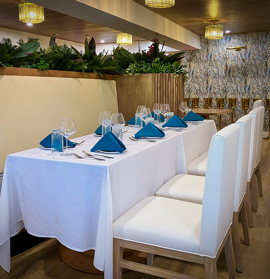 a table with white chairs and blue napkins