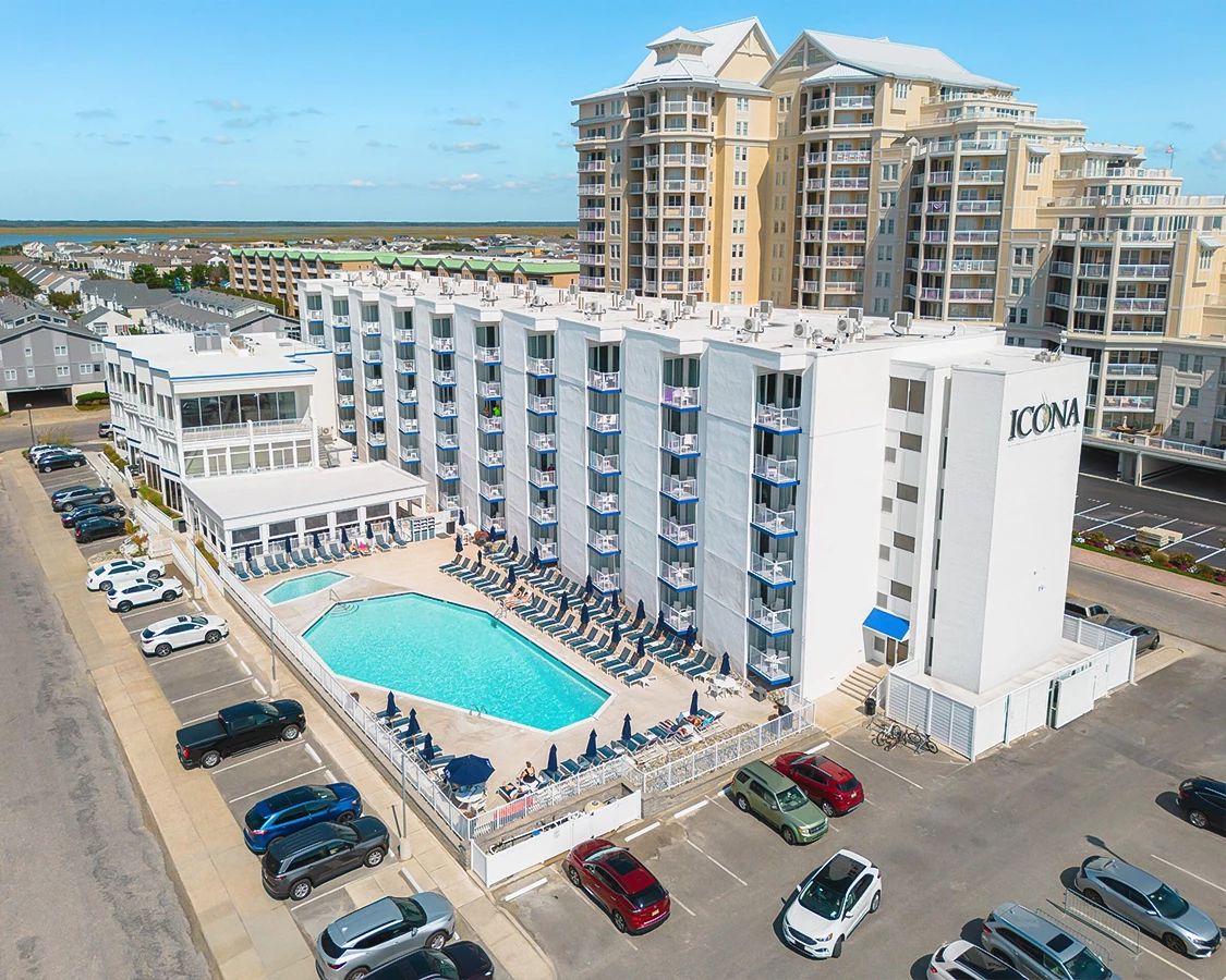 a building with a pool and cars parked in front of it