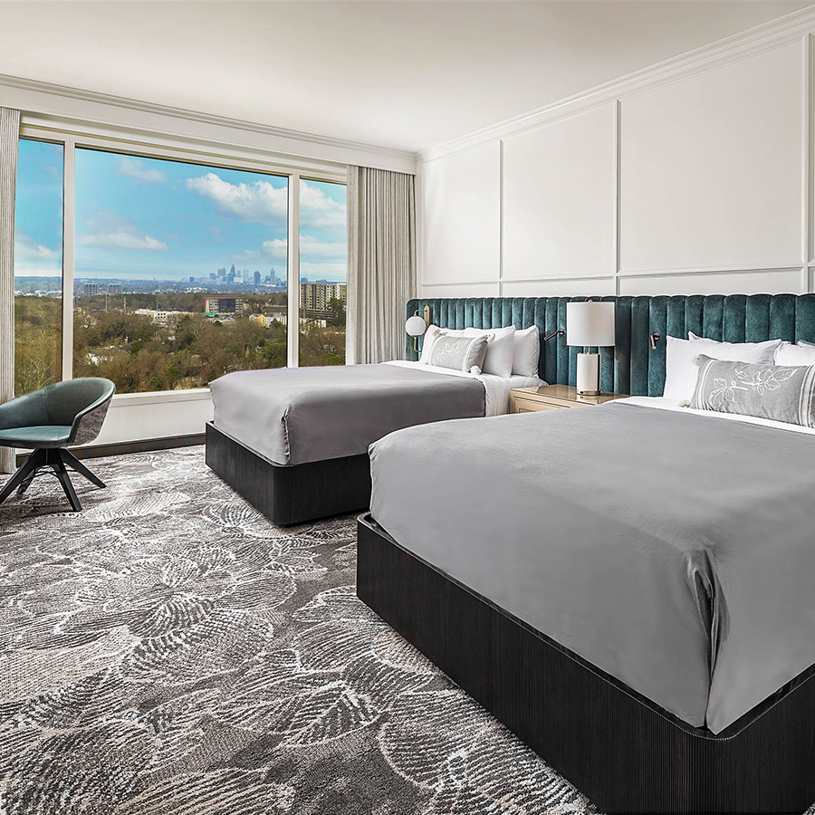 a room with two beds and a large window