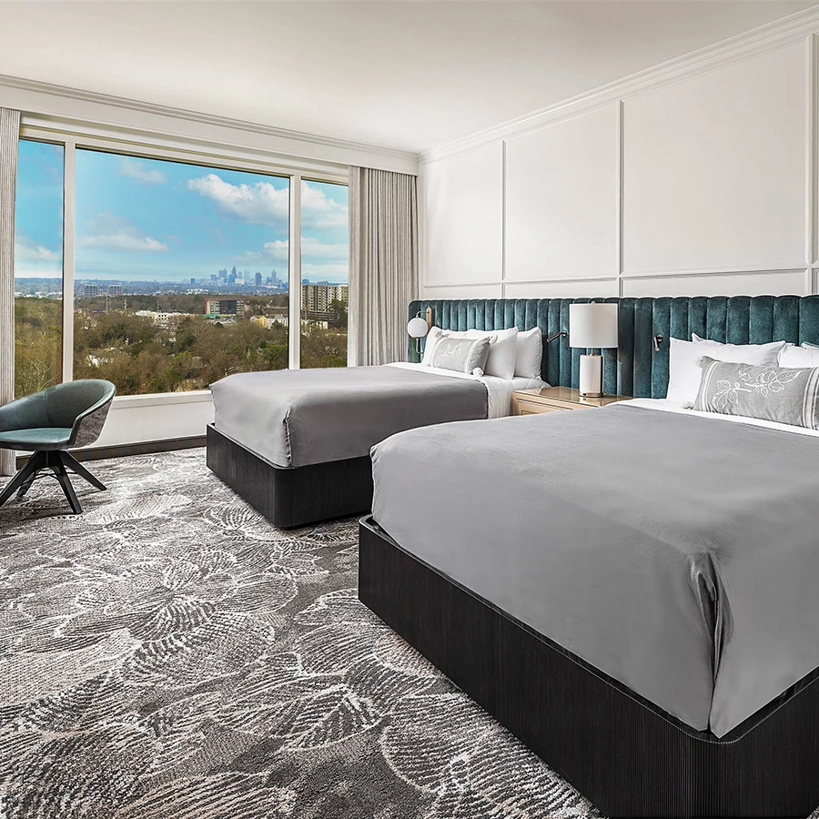 a room with two beds and a large window