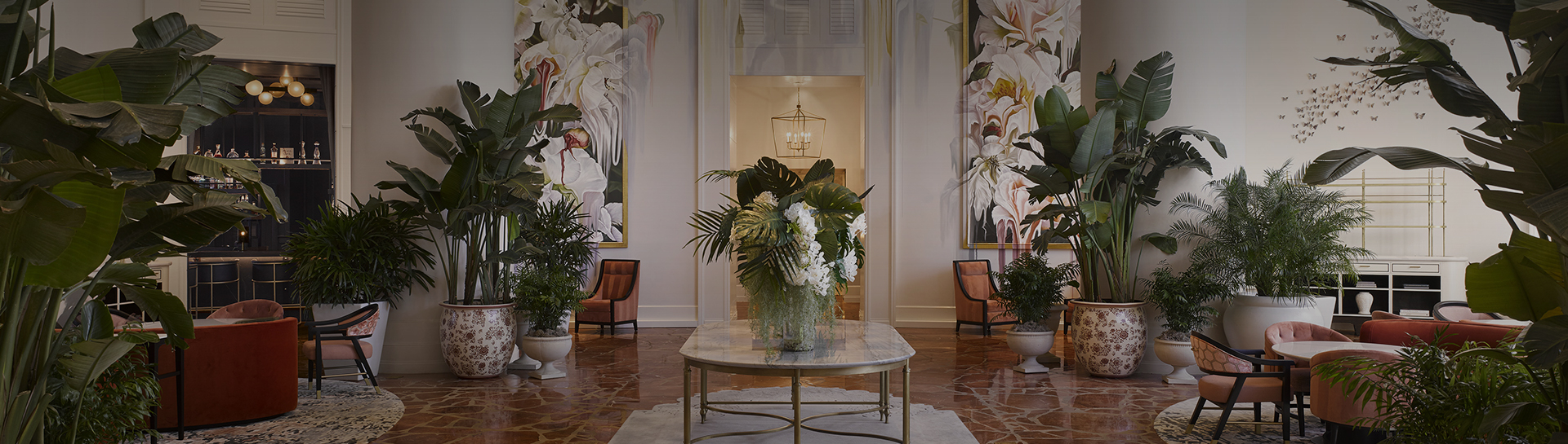 a large plant on a table in a room with paintings on the wall
