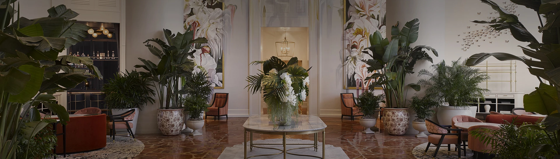 a large plant on a table in a room with paintings on the wall
