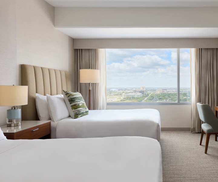 a hotel room with two beds and a window