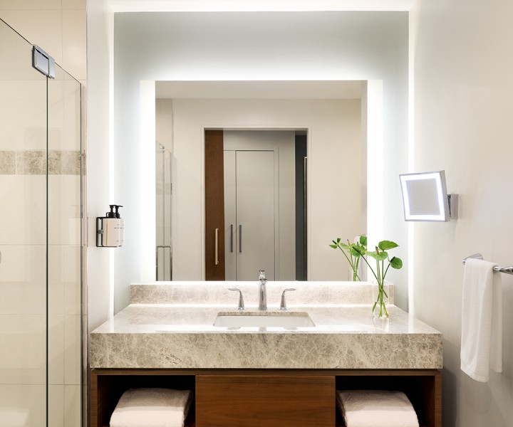 a bathroom with a marble countertop sink and a mirror