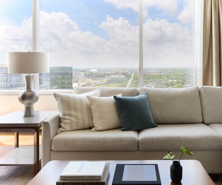 a couch with pillows and a lamp in front of a window