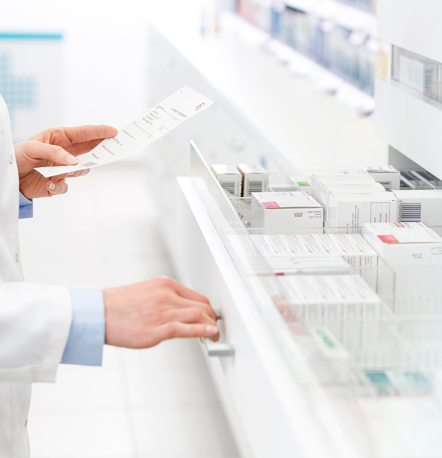 a person holding a paper in front of a shelf