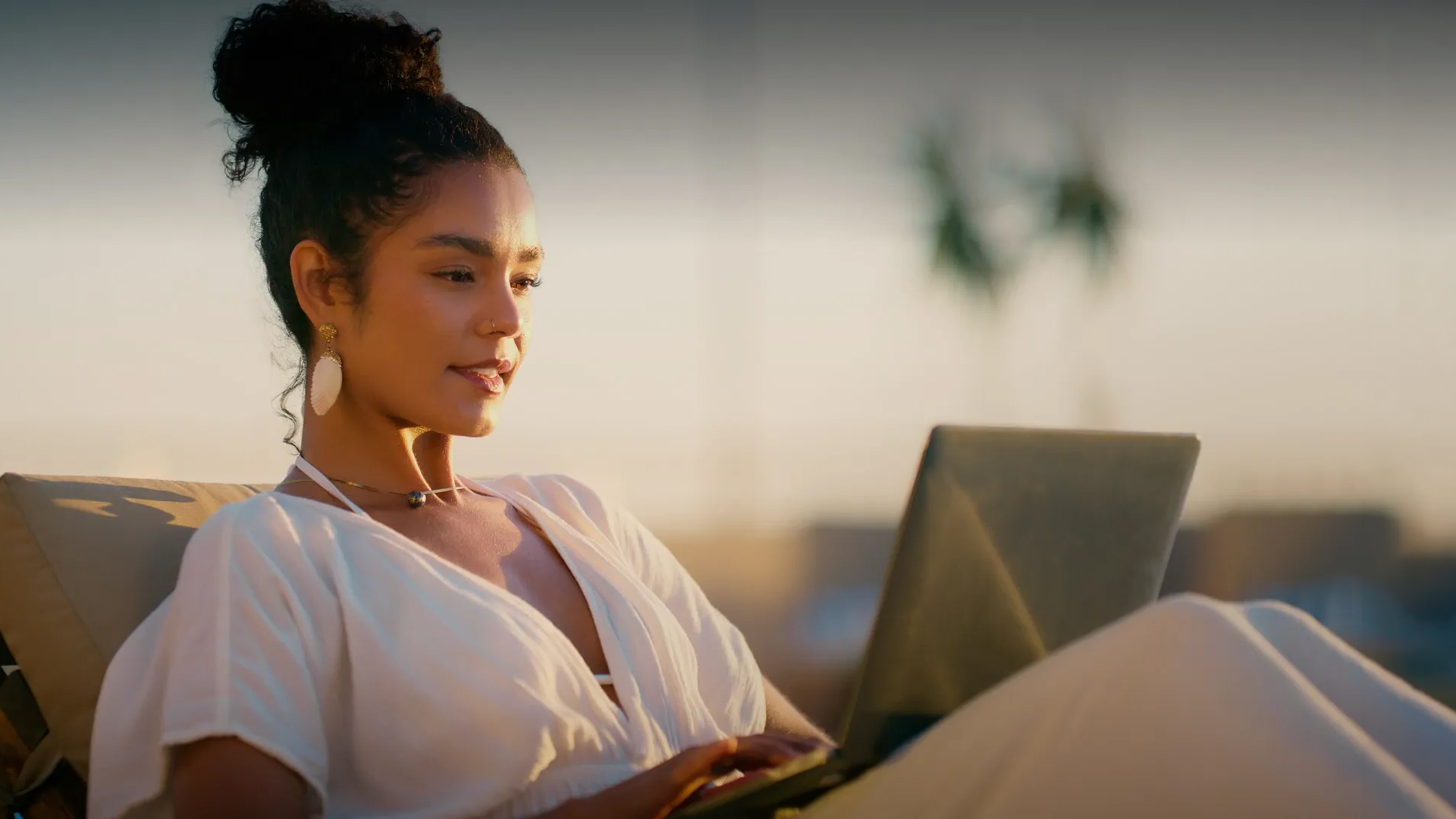 a woman sitting on a couch using a laptop
