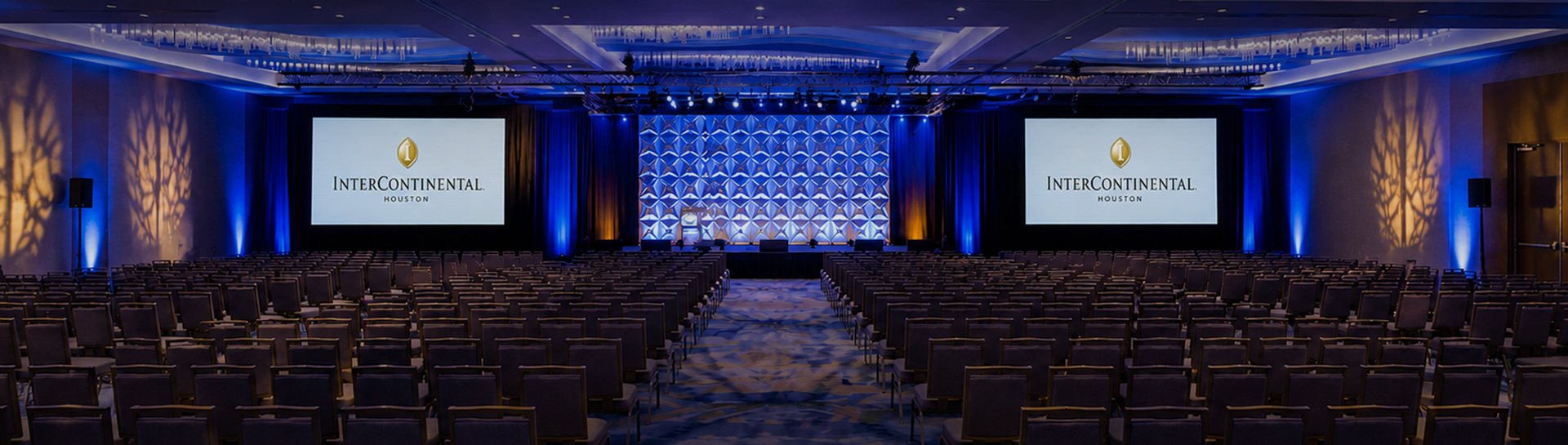 a room with chairs and a stage with blue lights