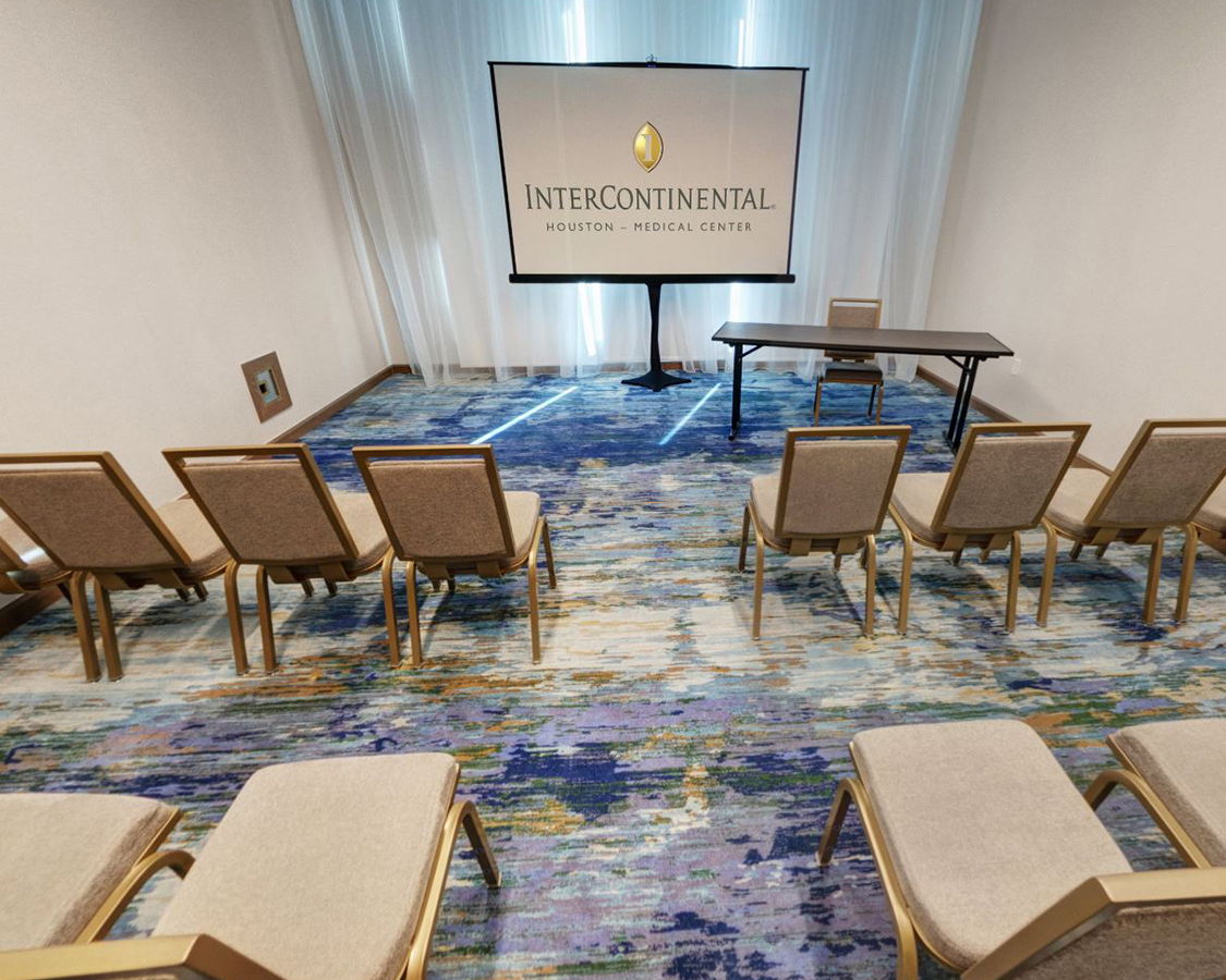 a room with chairs and a screen