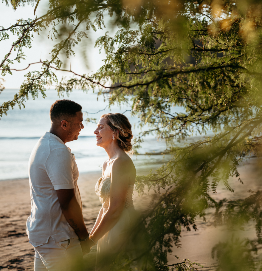 a man and woman standing on a beach holding hands
