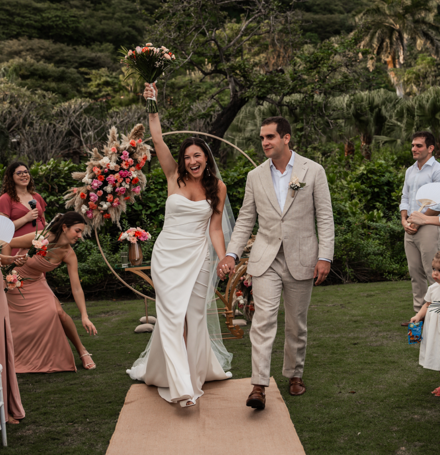 a man and woman walking down a path with flowers