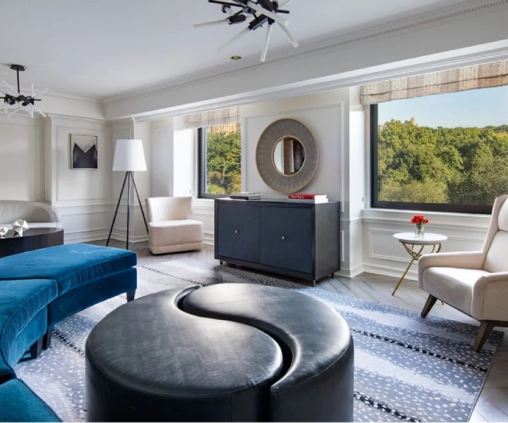 a room with a couch and a blue ottoman