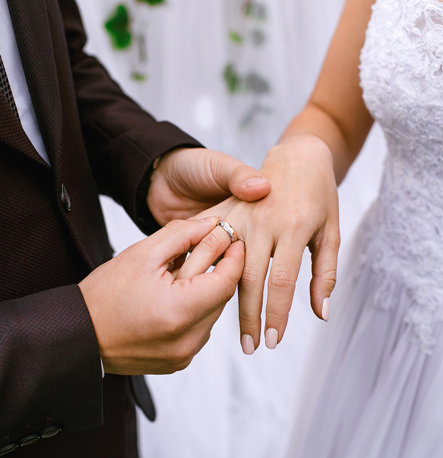 a man putting a ring on a woman's hand