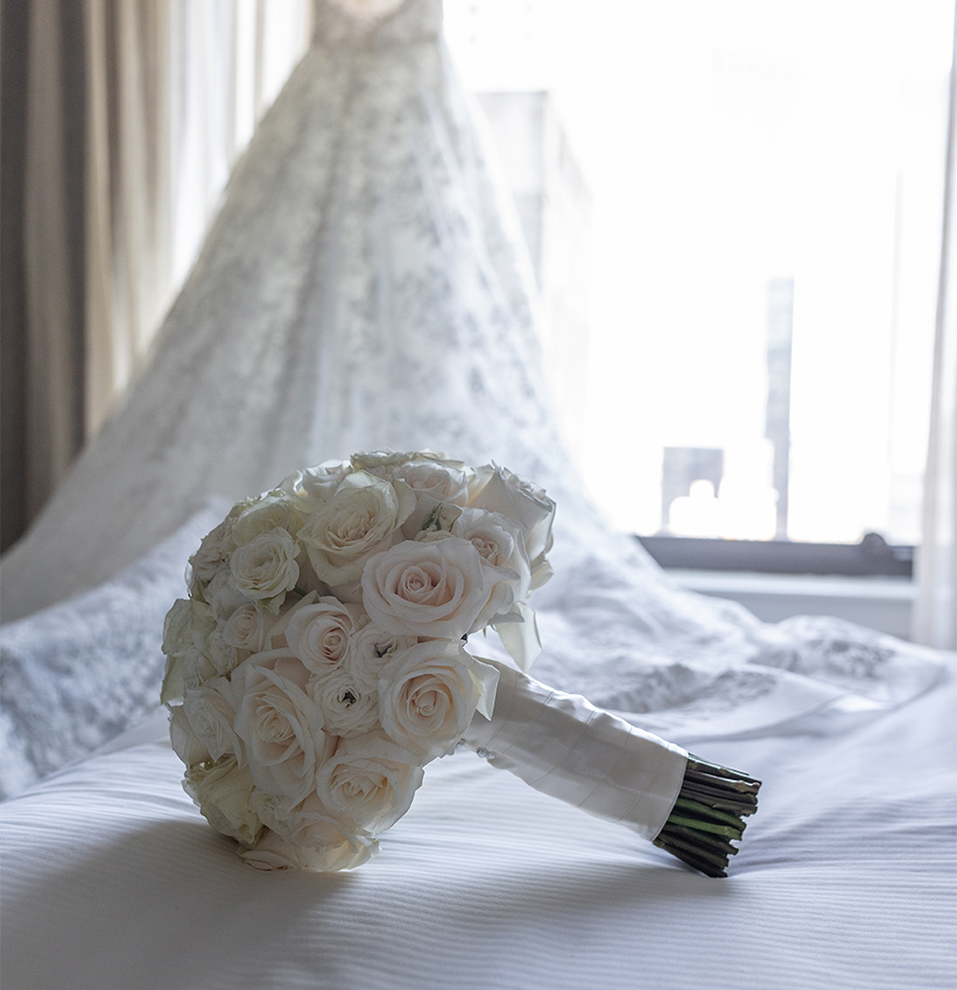 a bouquet of white roses on a bed