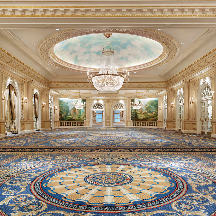 a large room with a chandelier and a blue carpet