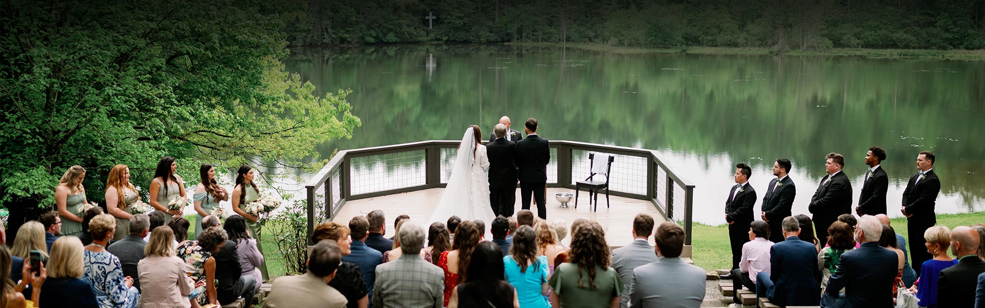 a group of people standing on a deck overlooking a lake