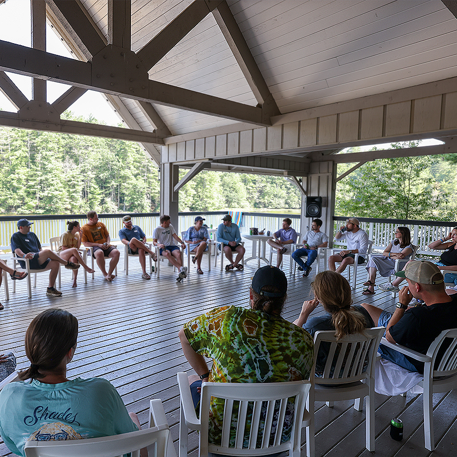 a group of people sitting in chairs on a deck
