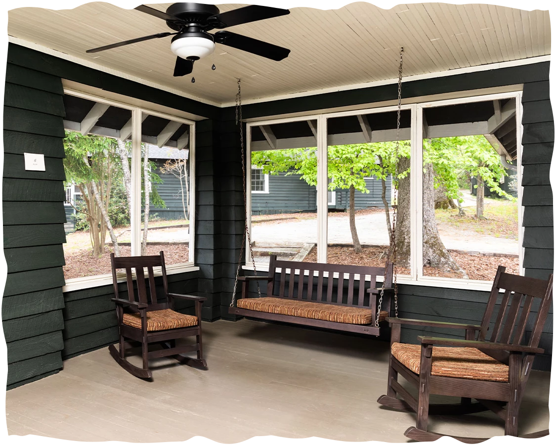 a porch with rocking chairs and a fan