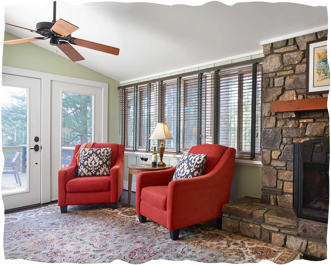 a living room with red chairs and a fireplace