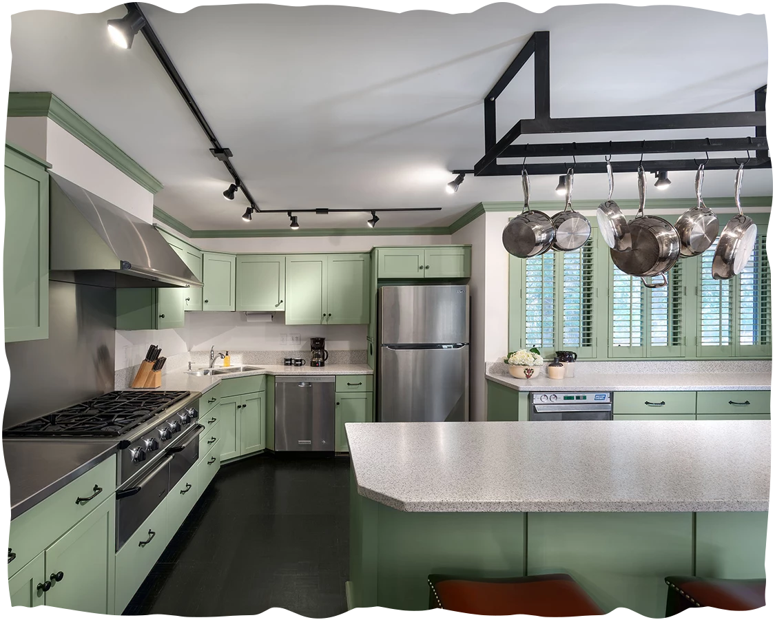 a kitchen with green cabinets and a white counter top