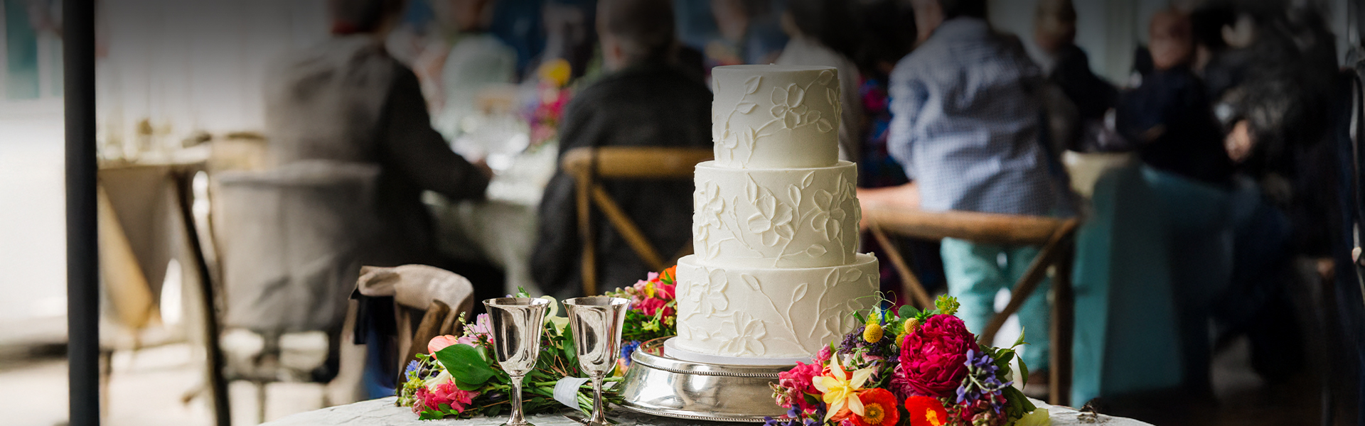a cake with flowers and glasses on a table