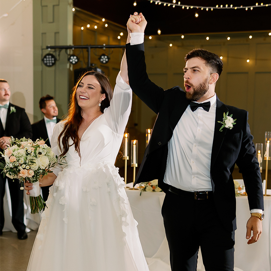 a man and woman holding hands up