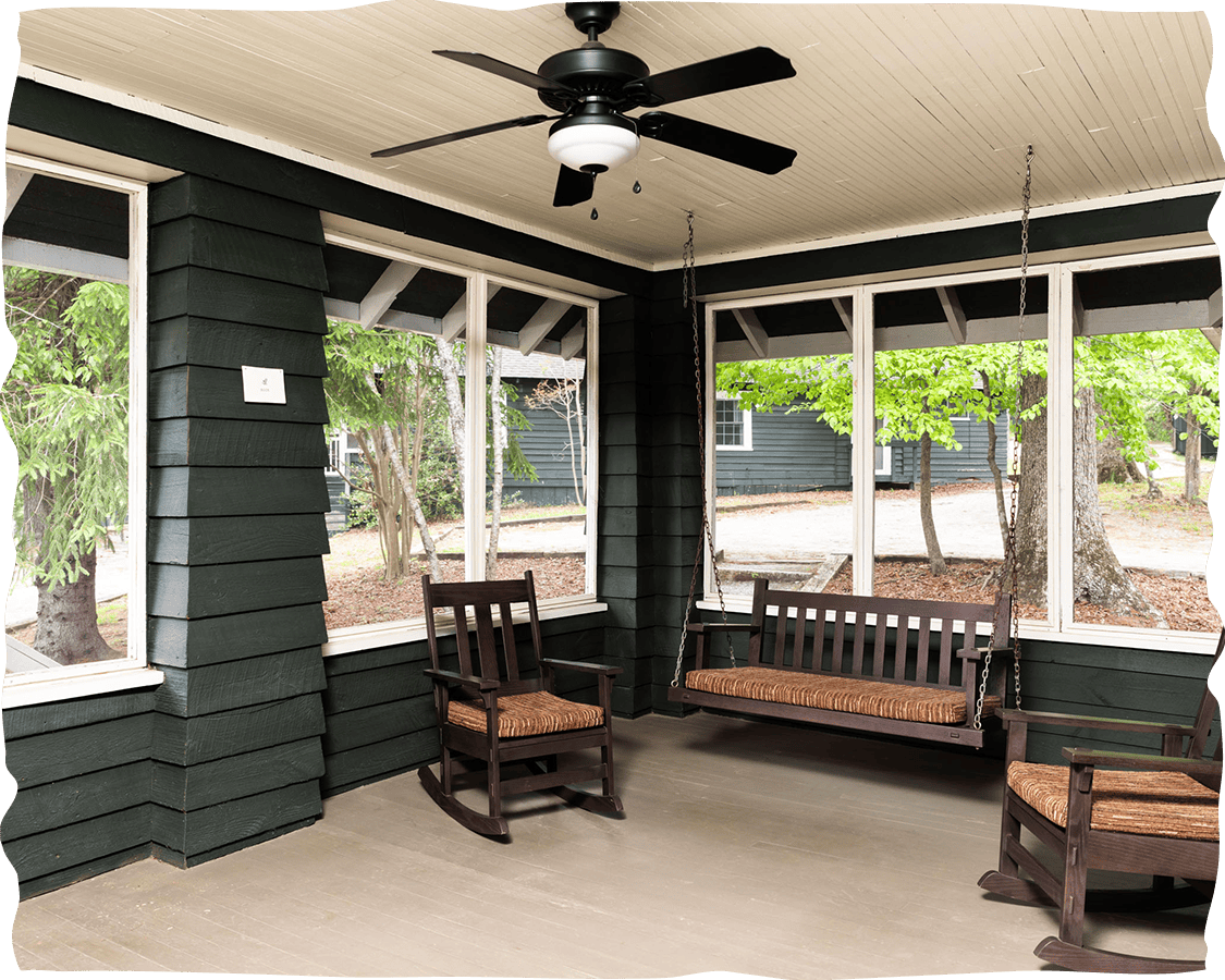 a porch with rocking chairs and a fan