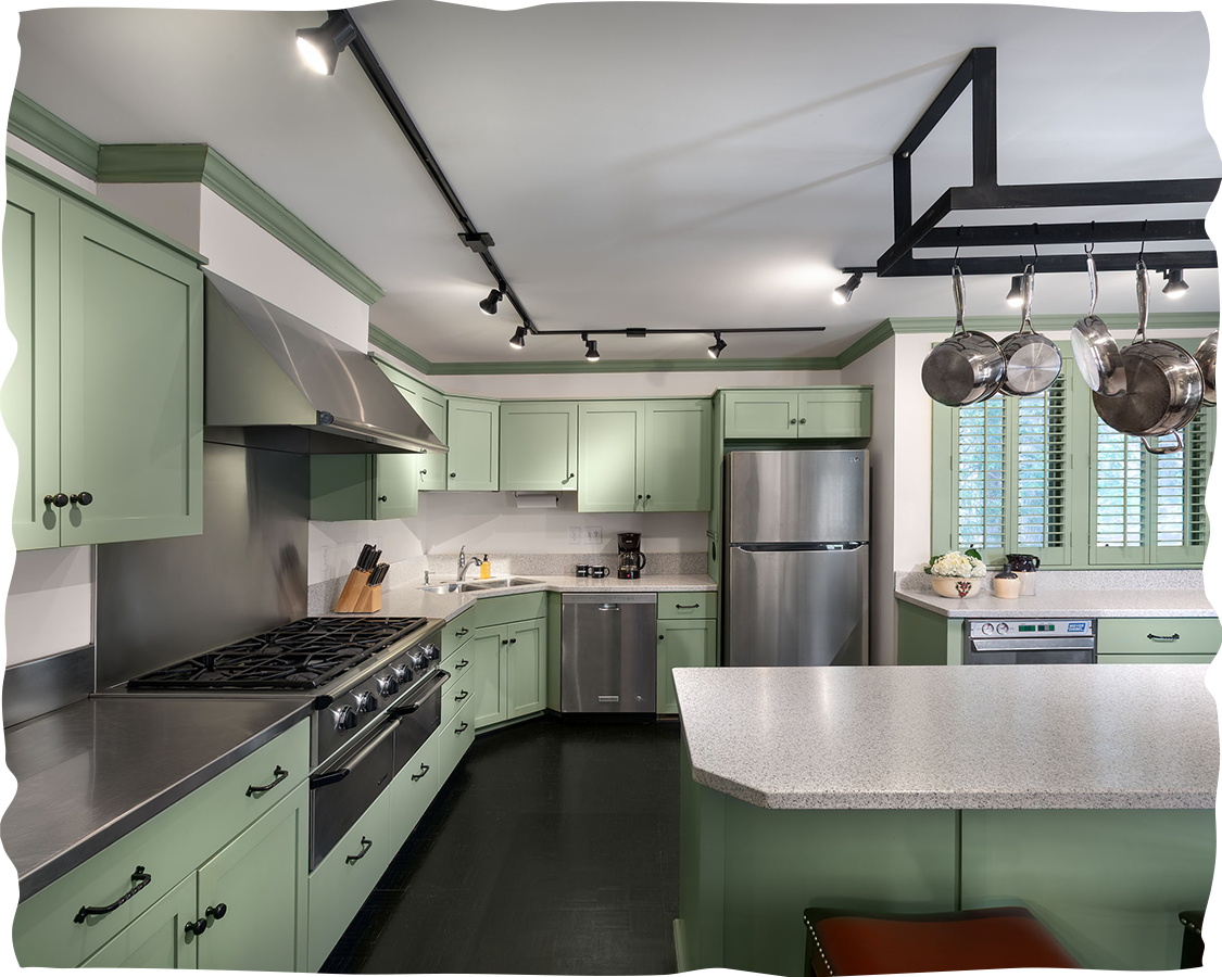 a kitchen with green cabinets and appliances