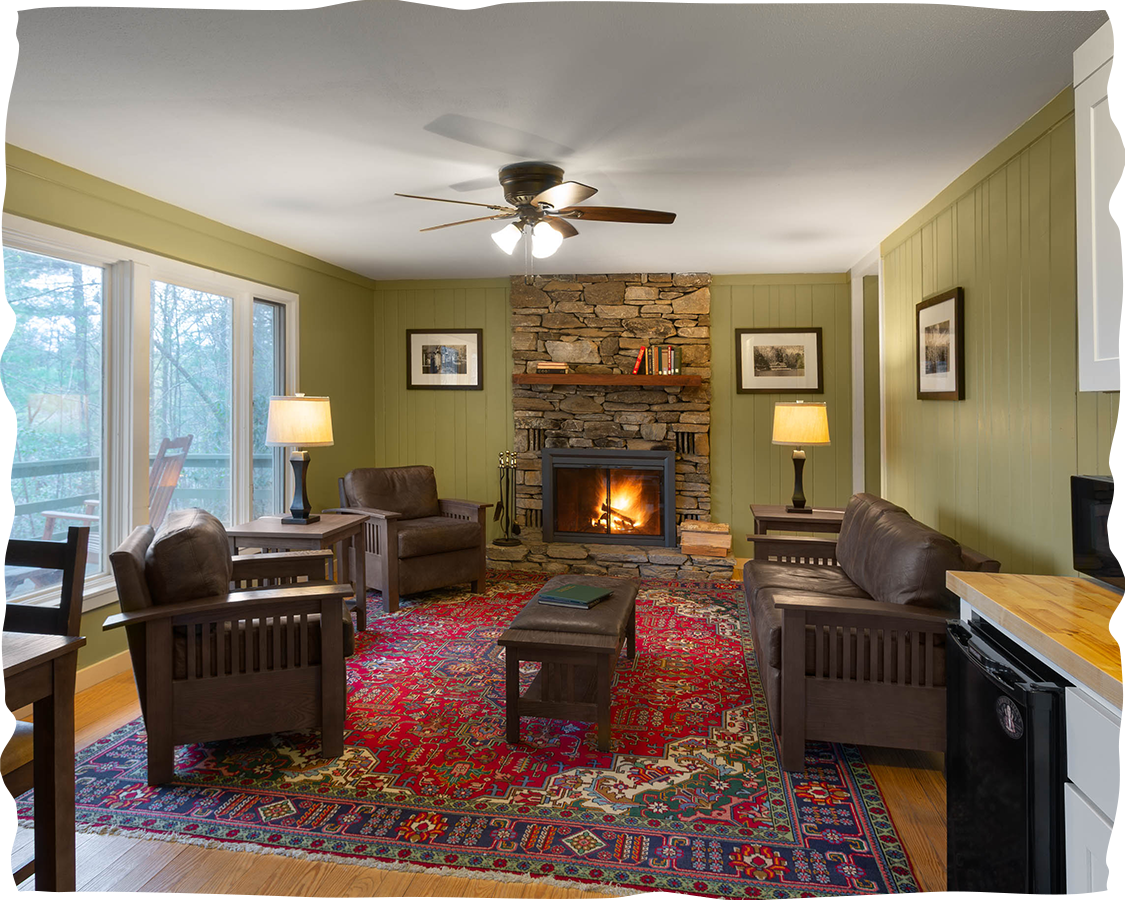 a living room with a fireplace and chairs