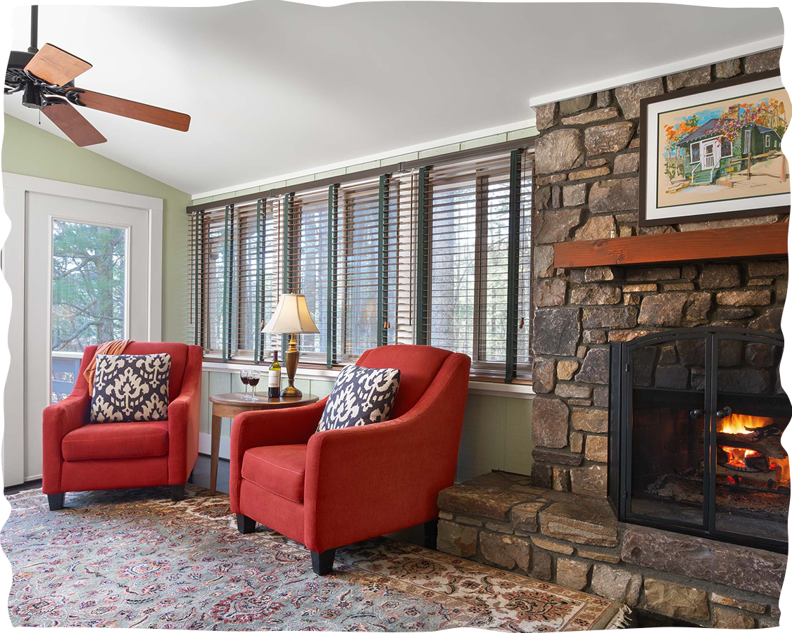a living room with red chairs and a fireplace