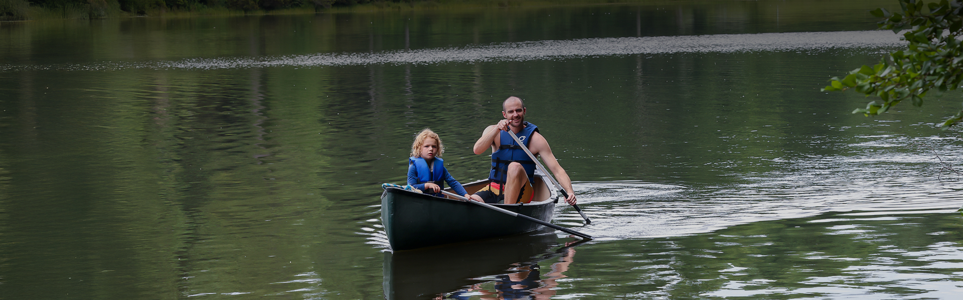 a man and child in a canoe on a lake