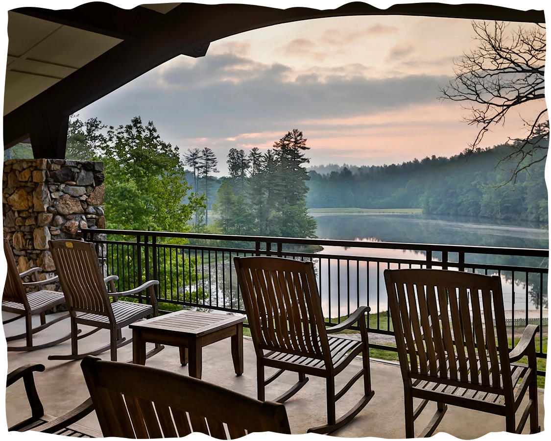 a deck with chairs and a lake