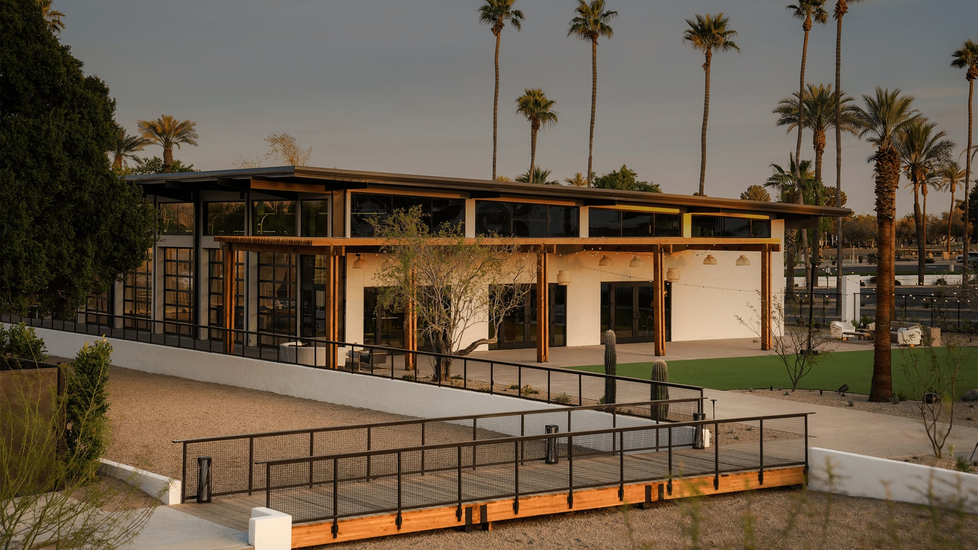 a building with a walkway and palm trees