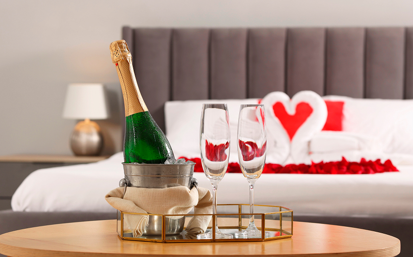 a champagne bottle in a bucket and two champagne glasses on a tray