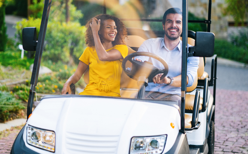 a man and woman in a golf cart