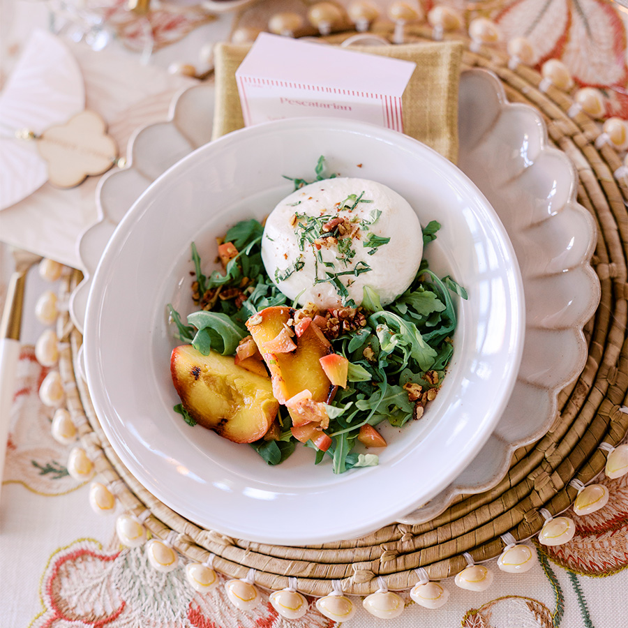 a bowl of salad with peaches and cheese