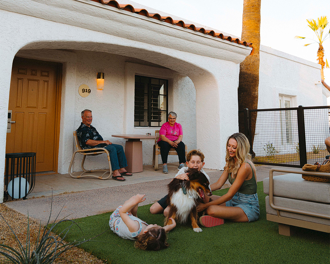 a group of people sitting on grass with a dog