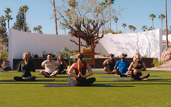 a group of people sitting on mats in a circle